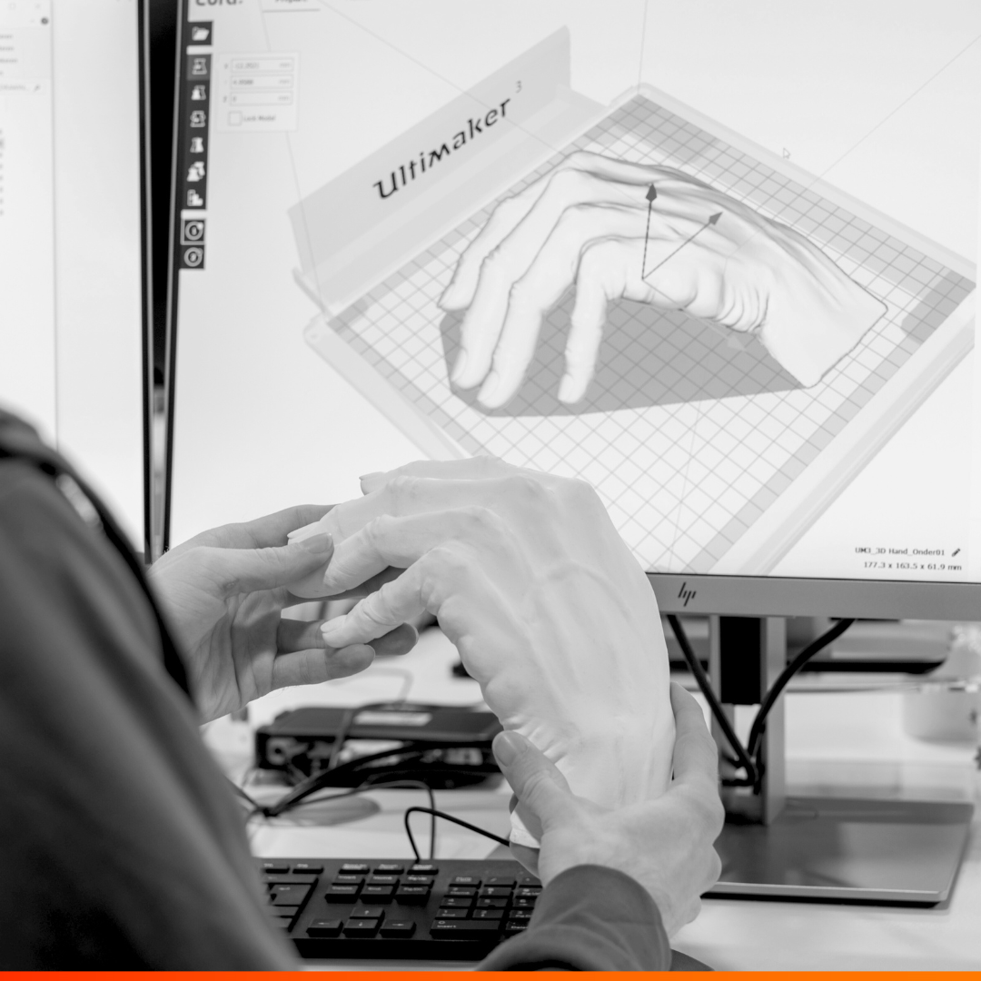 3D geprinte hand met een schets van de hand op beeldscherm